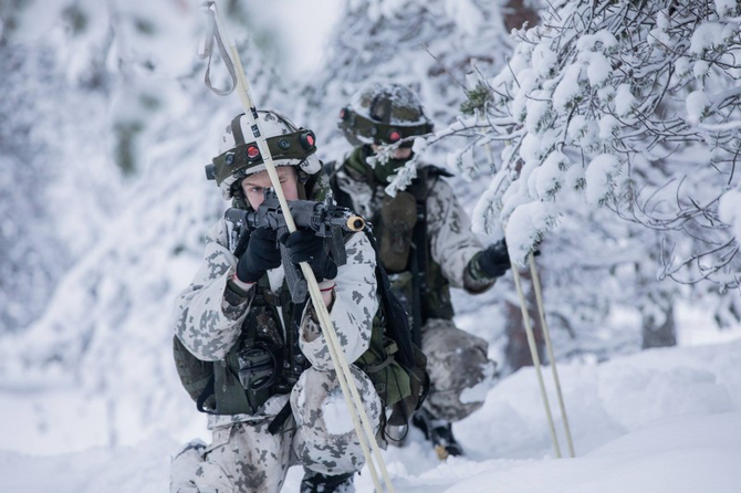 芬兰士兵用雪橇翻越雪山,穿着白色制服,与雪地融为一体,对苏军切割