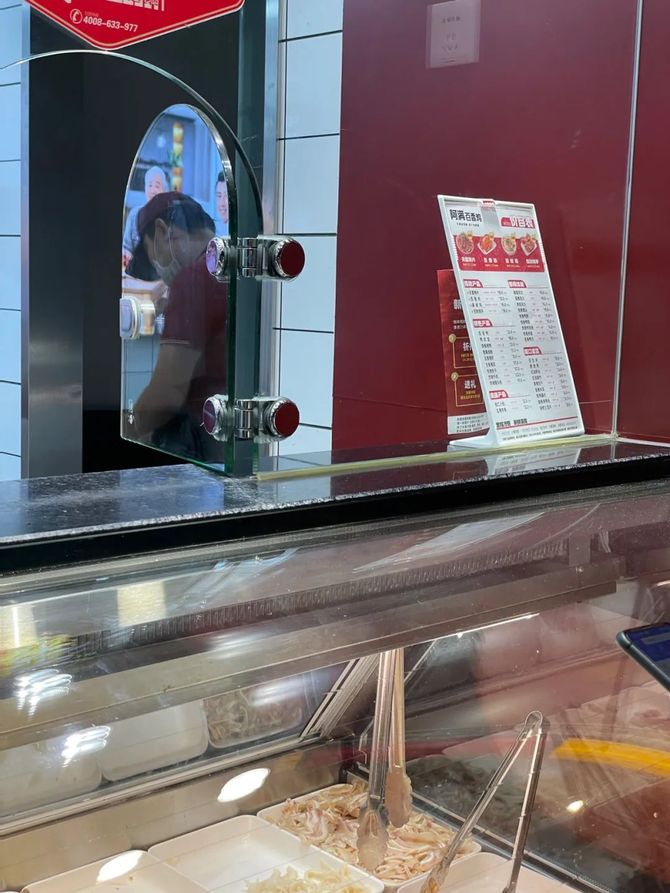 这家卤菜店的橱窗分出了点餐与取餐的两个玻璃小门,其中点餐的这扇门