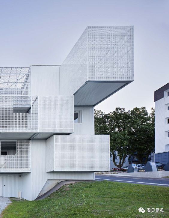 建筑在与整个社区成为一体同时通过穿孔面板保护居民,减少外界视线和